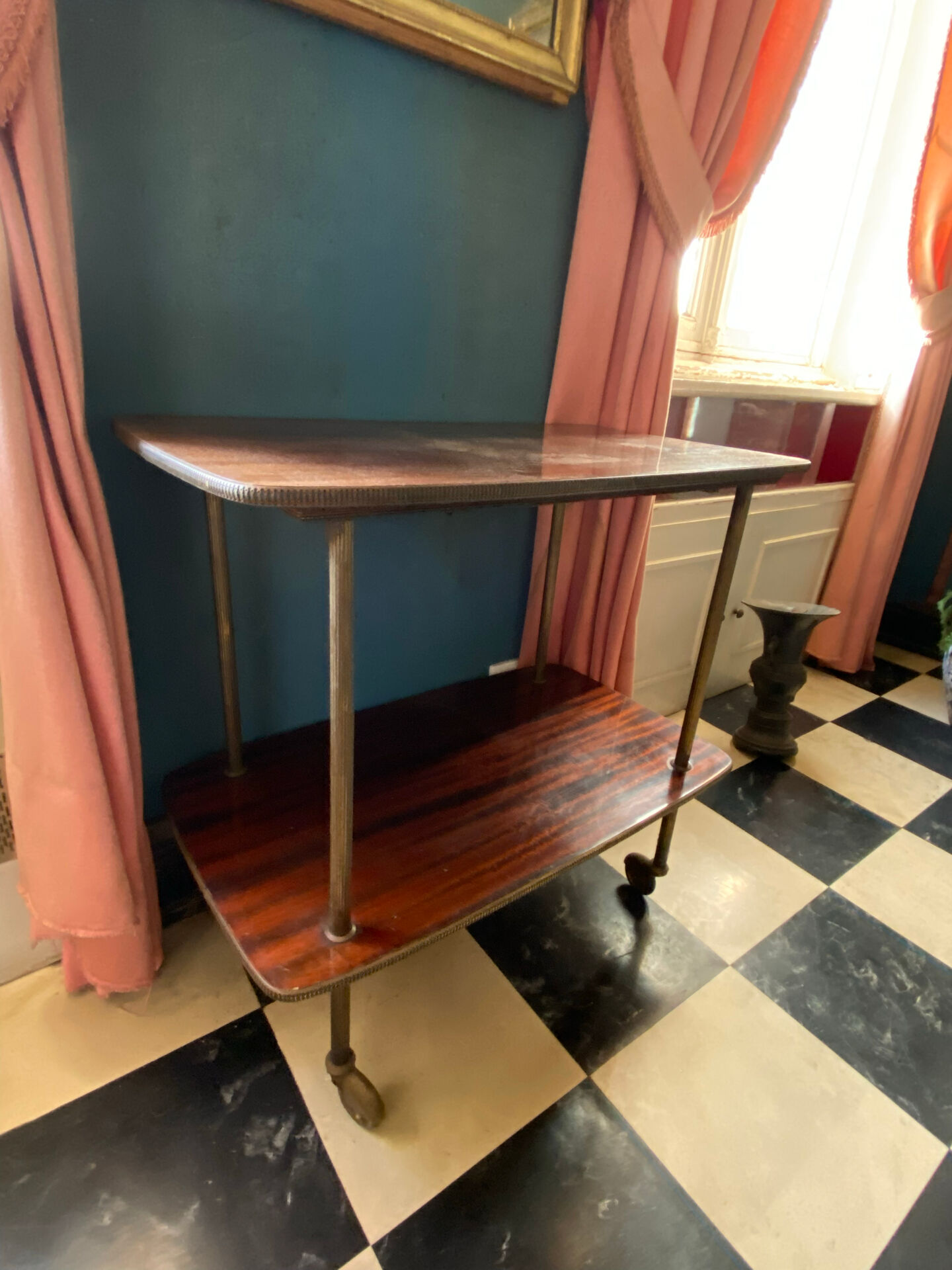 Elegant vintage serving trolley on wheels, two wooden shelves.