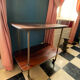 Elegant vintage serving trolley on wheels, two wooden shelves.