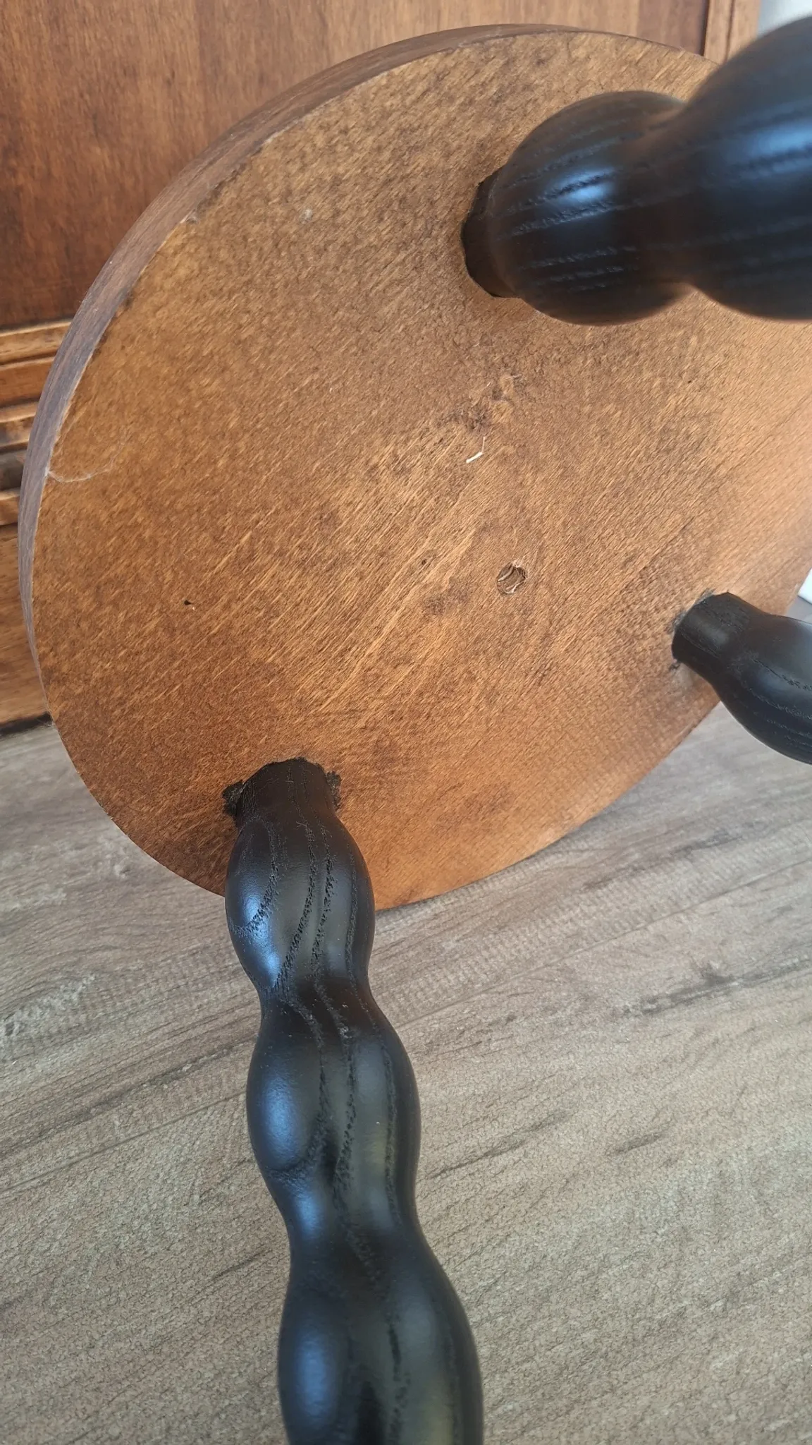 Brown and black wooden tripod stool