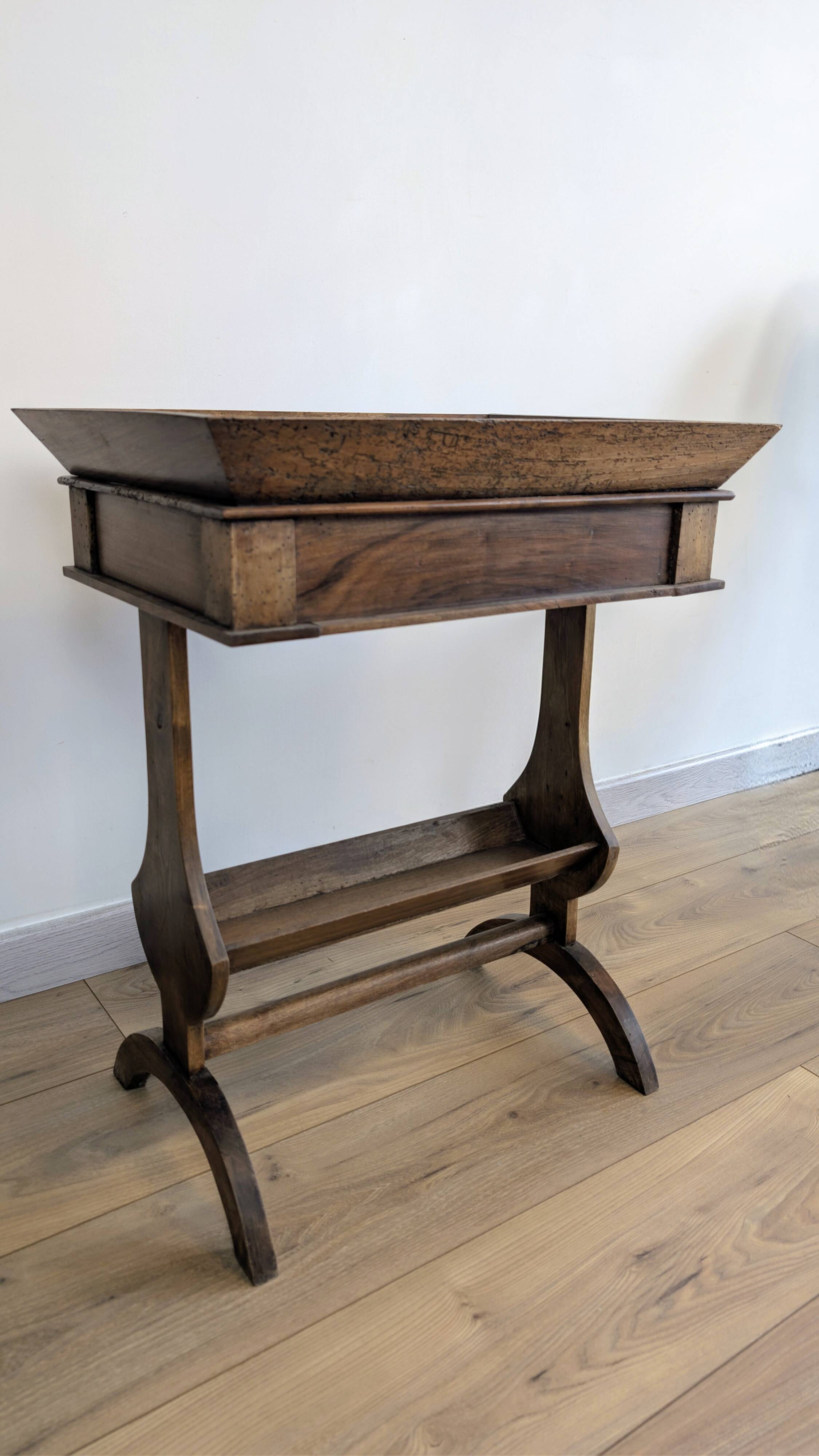 Old wooden pocket emptying table with drawer and planter.