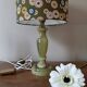Table lamp with light green onyx base, fabric shade with a khaki background.