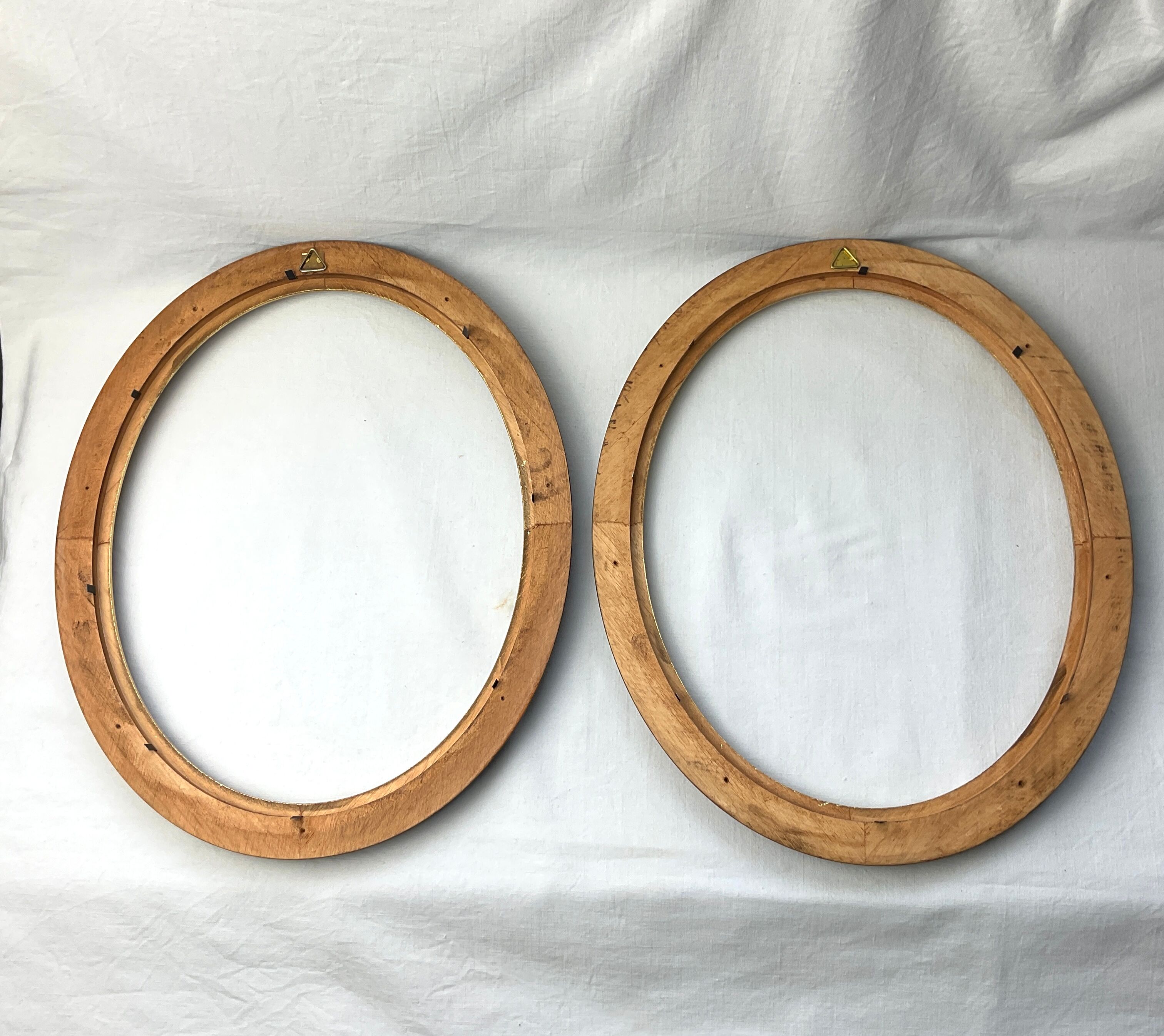 Pair of oval wooden frames with gilding