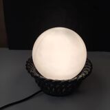 Table lamp with black porcelain support in the shape of a woven basket and opaque glass ball globe
