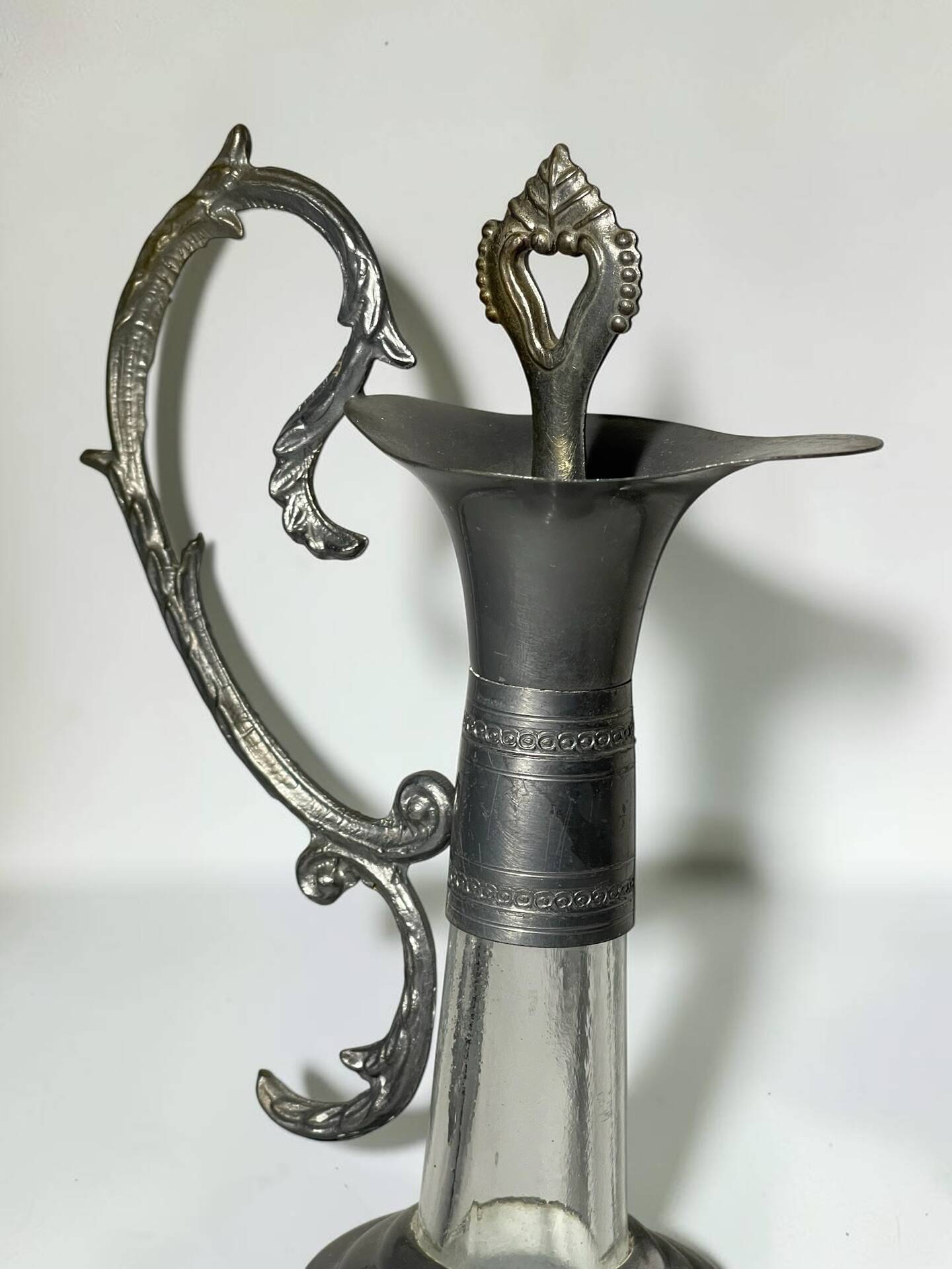 Vintage glass decanter with cut design and silver-plated metal, stopper included.