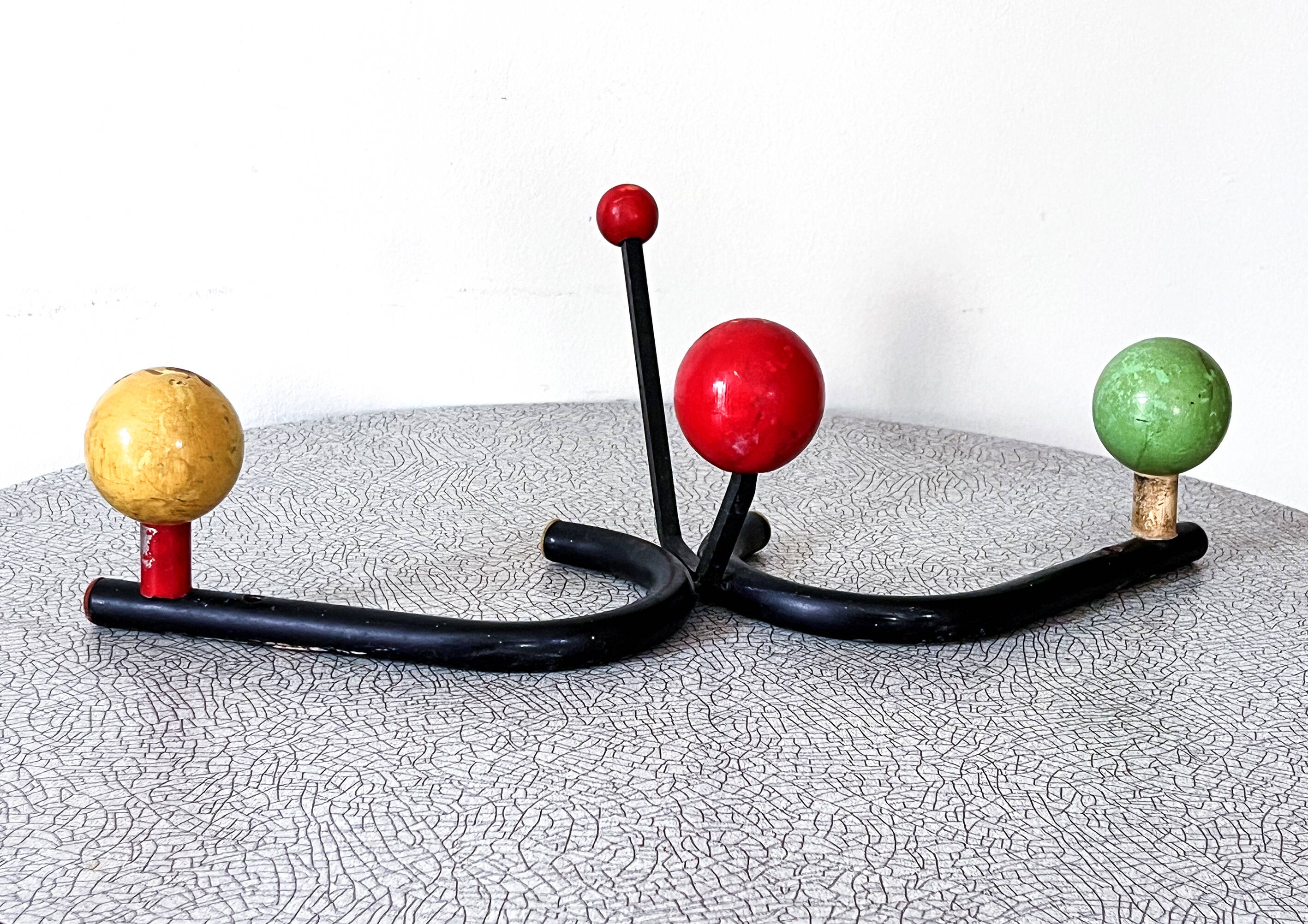 Vintage metal and wood coat rack in yellow/red/green.