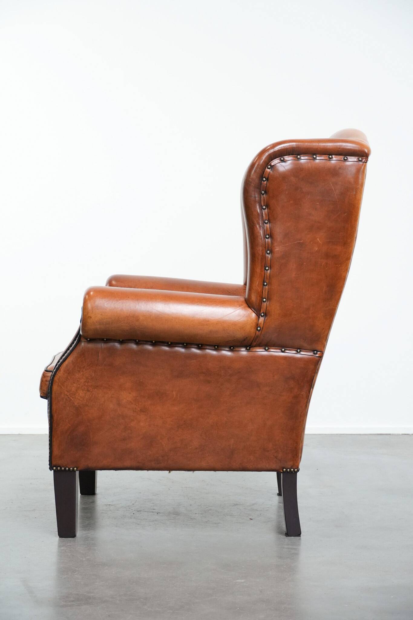 Wingback chair made of sheep leather with black piping in good condition