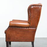 Wingback chair made of sheep leather with black piping in good condition