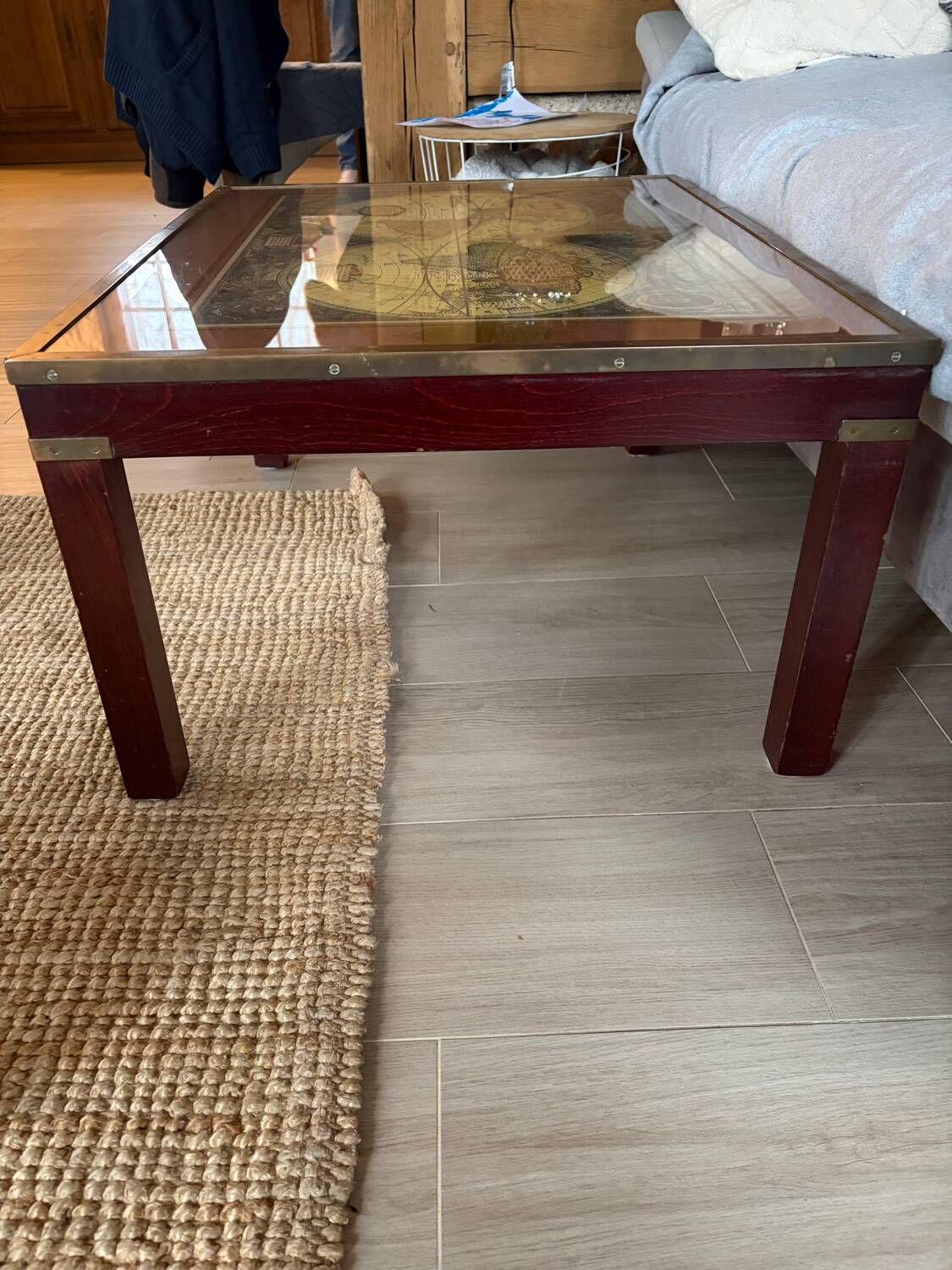 Wood and brass coffee table with a world map under glass.
