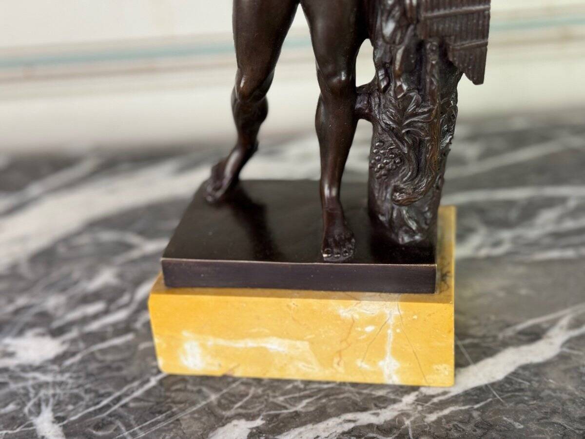 Dionysus on the shoulders of a satyr, bronze after the antique on a yellow Siena base.