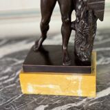 Dionysus on the shoulders of a satyr, bronze after the antique on a yellow Siena base.