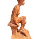 Painted plaster sculpture of a nude woman on a bench