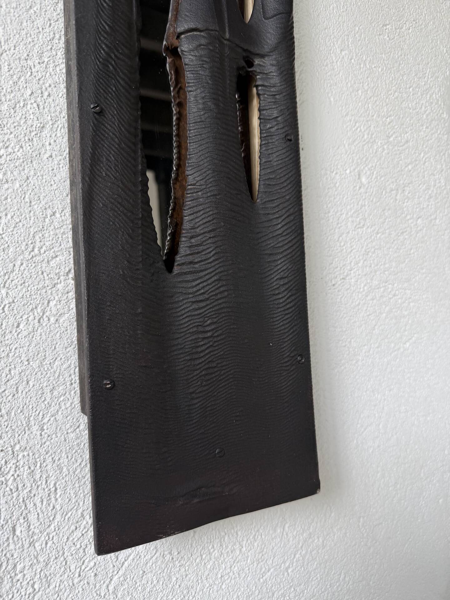 Brutalist hammered mirror, free-form, patinated metal.