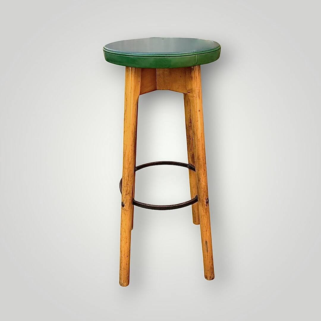 Old solid wood bar stool, metal footrest, green leatherette seat