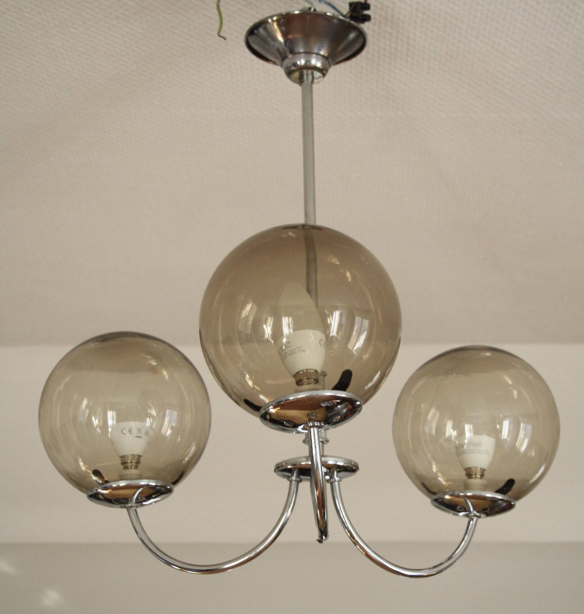 Chrome metal chandelier with smoked glass globes.