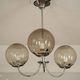 Chrome metal chandelier with smoked glass globes.
