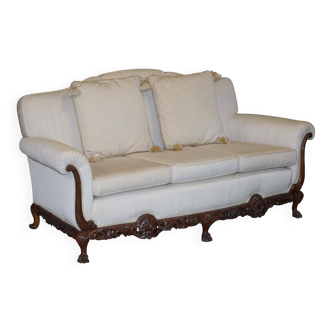 Three-seater canapé carved from solid walnut with claw feet.
