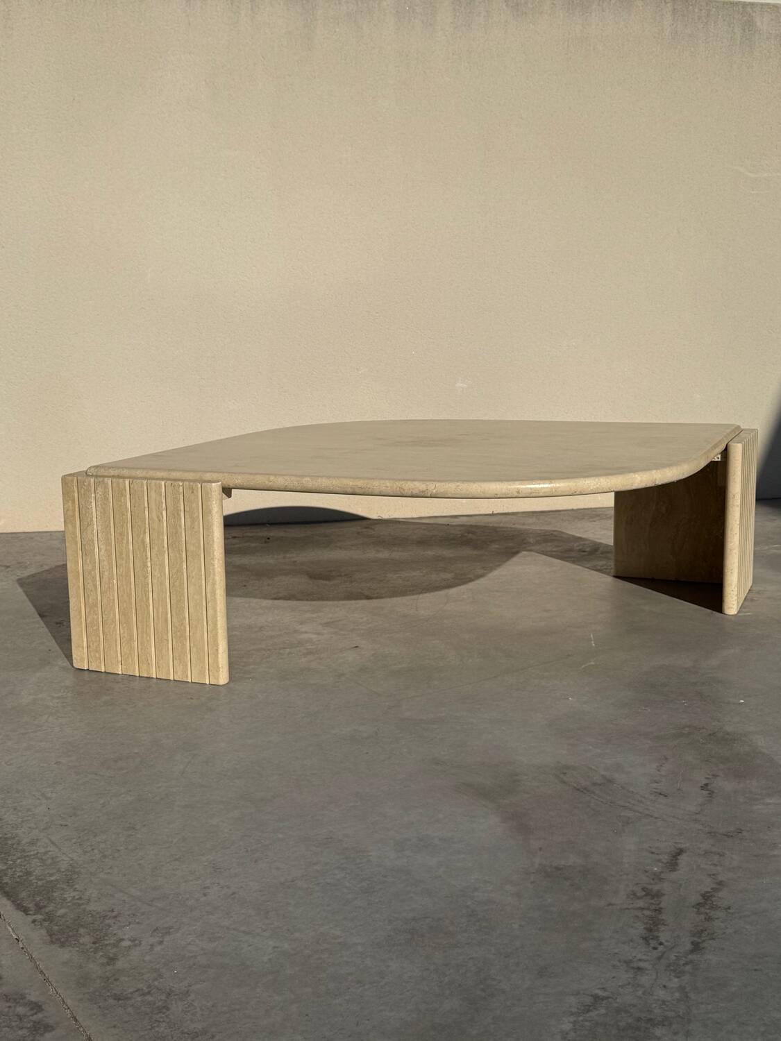 Large designer coffee table in travertine, eye shape, Roche Bobois edition from the 80s