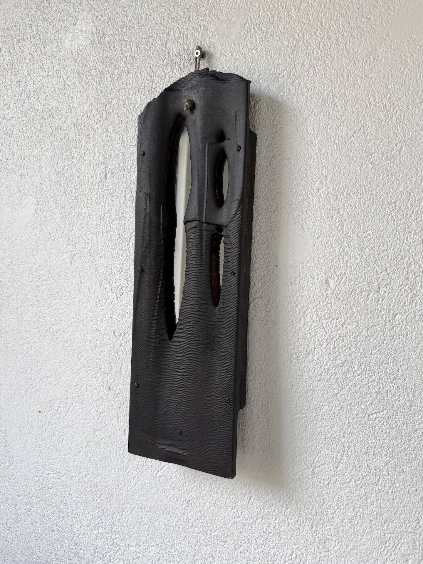 Brutalist hammered mirror, free-form, patinated metal.