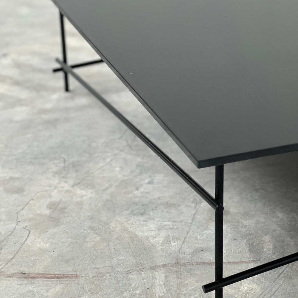 Minimalist black glass coffee table with industrial metal base