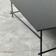 Minimalist black glass coffee table with industrial metal base