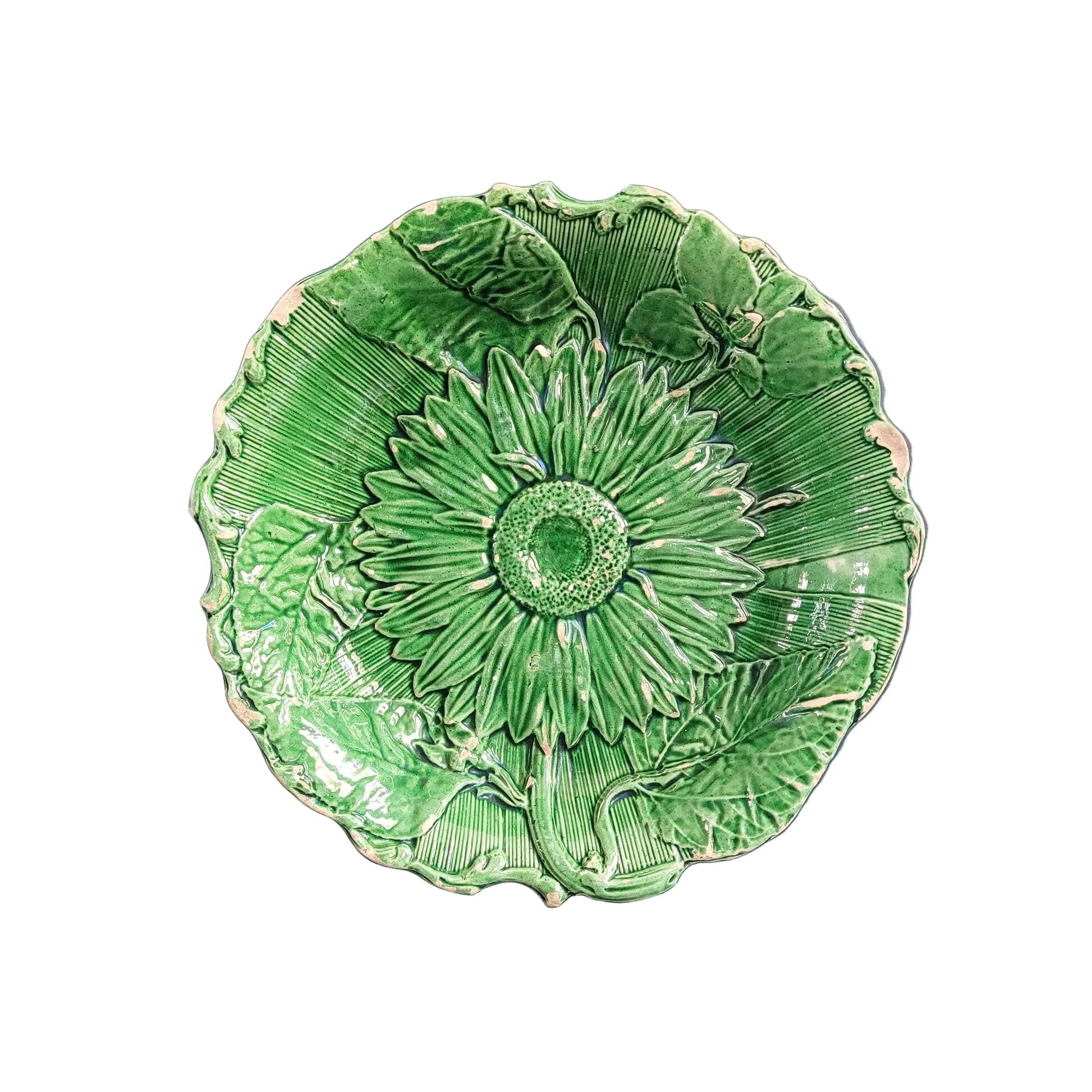 Plate decorated with a sunflower motif in slipware.