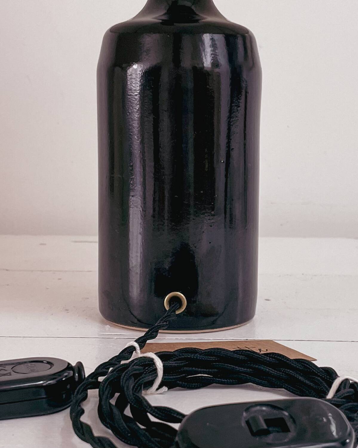 Black earthenware lamp and gingham lampshade