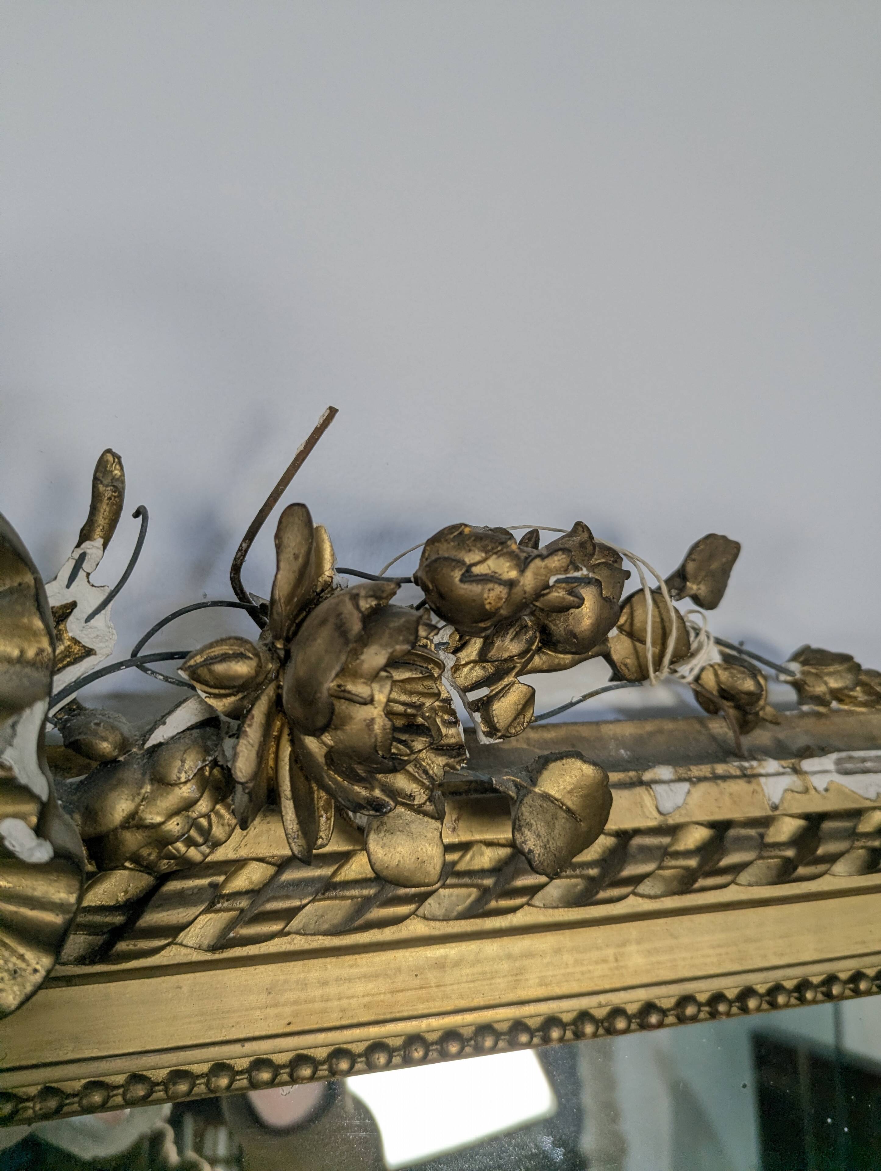 Golden Louis XVI style mirror with bouquet and shells.