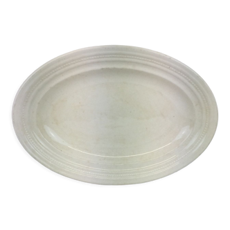 Old artisanal dish of ivory color, oval shape, with cracked effects