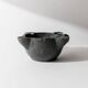 Vintage ceramic ashtray from the 1960s, black, hand-sculpted texture, organic shape.