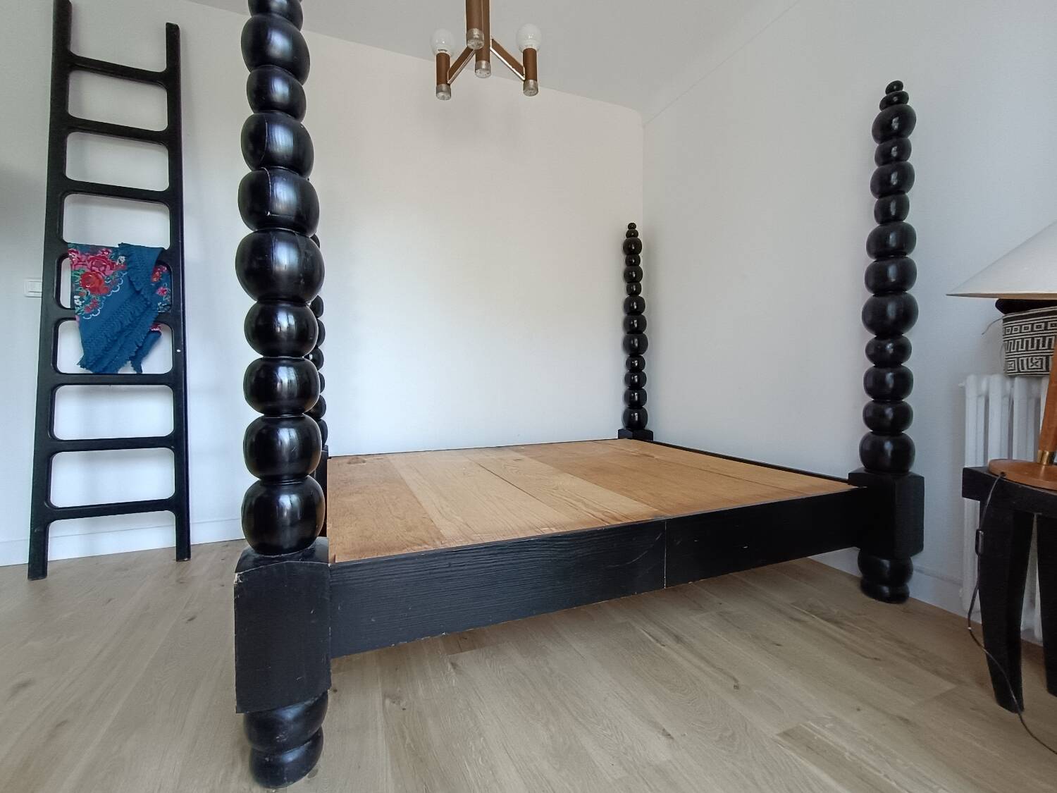 Black, solid wood four-poster bed, made by a craftsman in Mexico