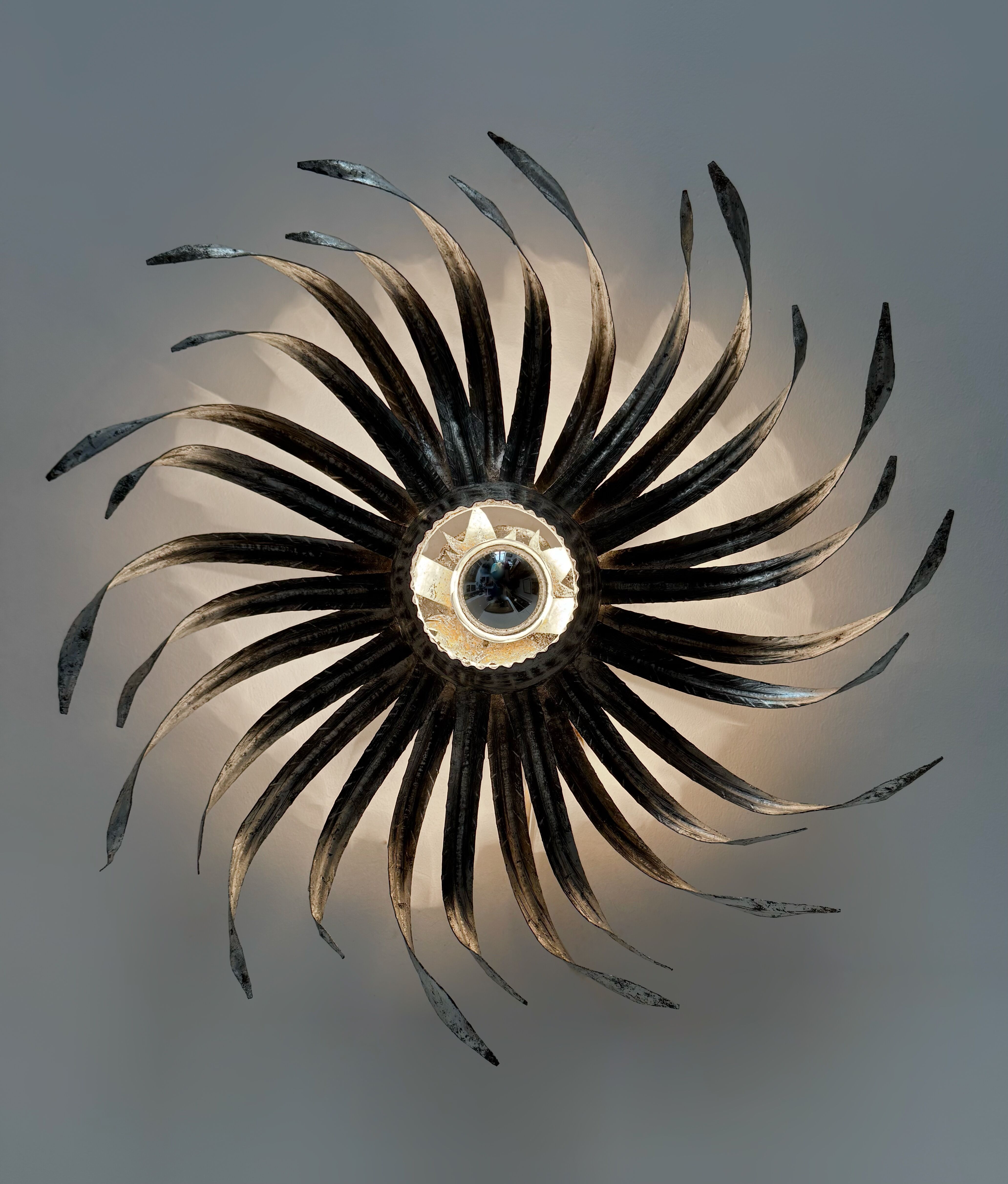 Silver wrought iron sunburst wall light from the 1960s.