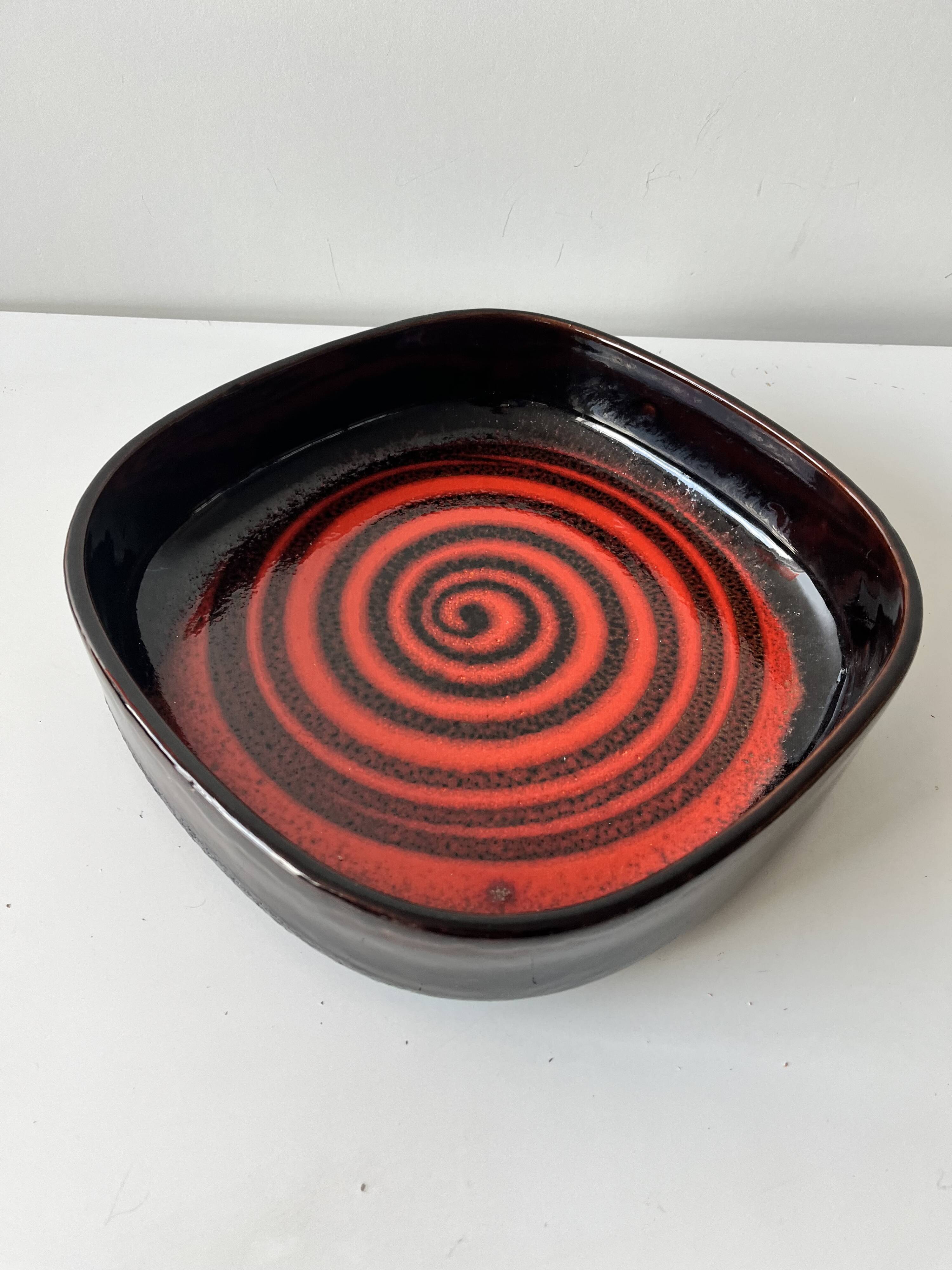 Large decorative ceramic catchall with red and black spiral pattern.