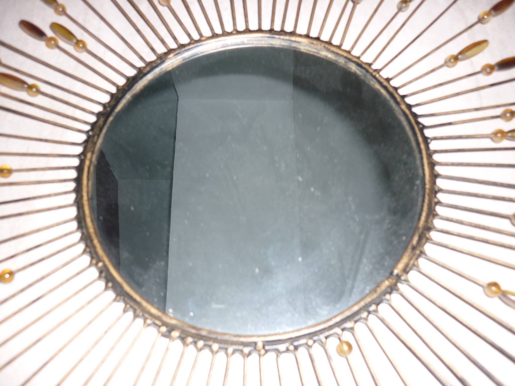 Round sun mirror with pearl rays and leaves