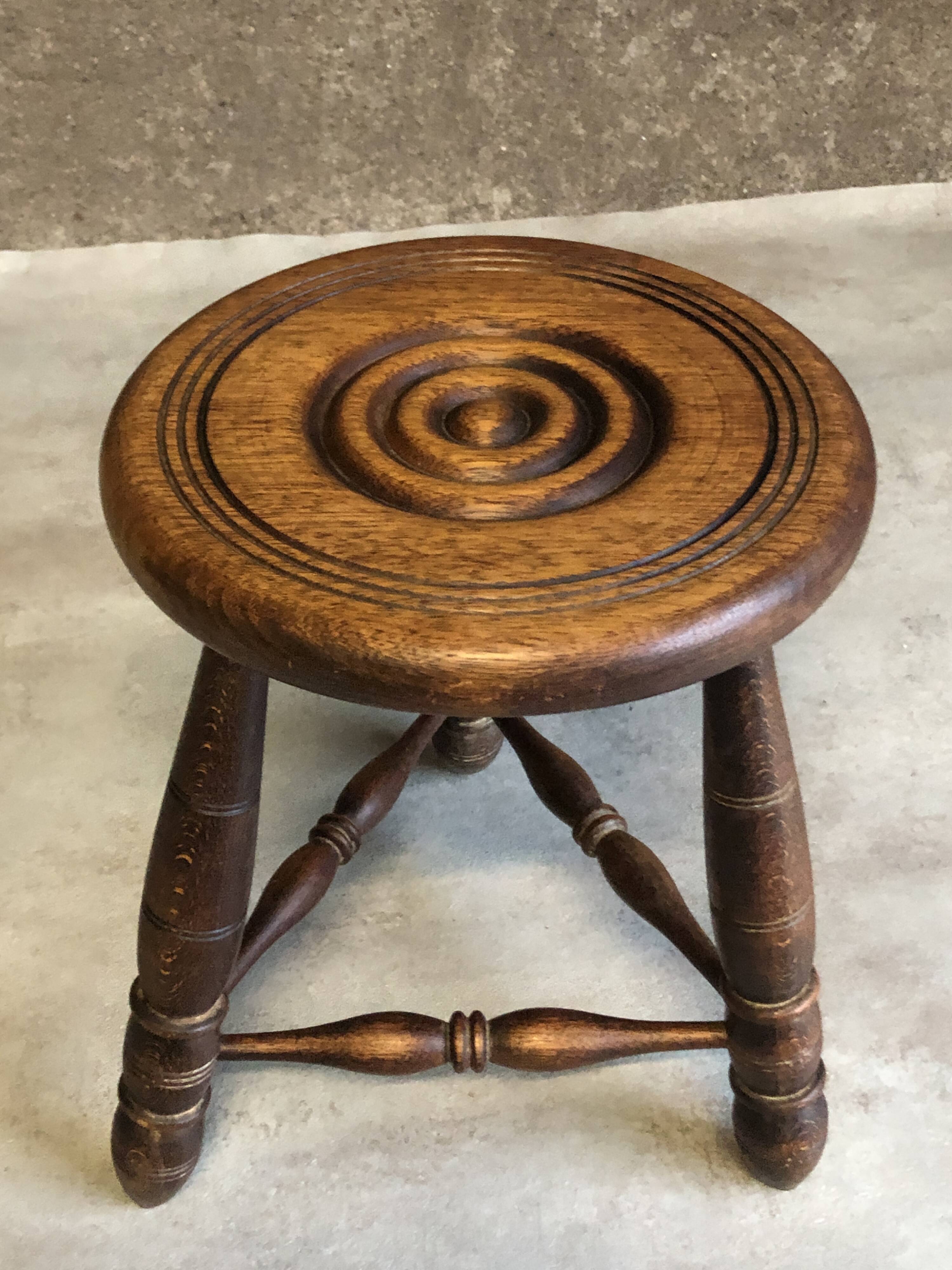 Round tripod stool in dark wood