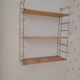 Vintage modular wall shelf in golden steel wire and wood from the 1950s.
