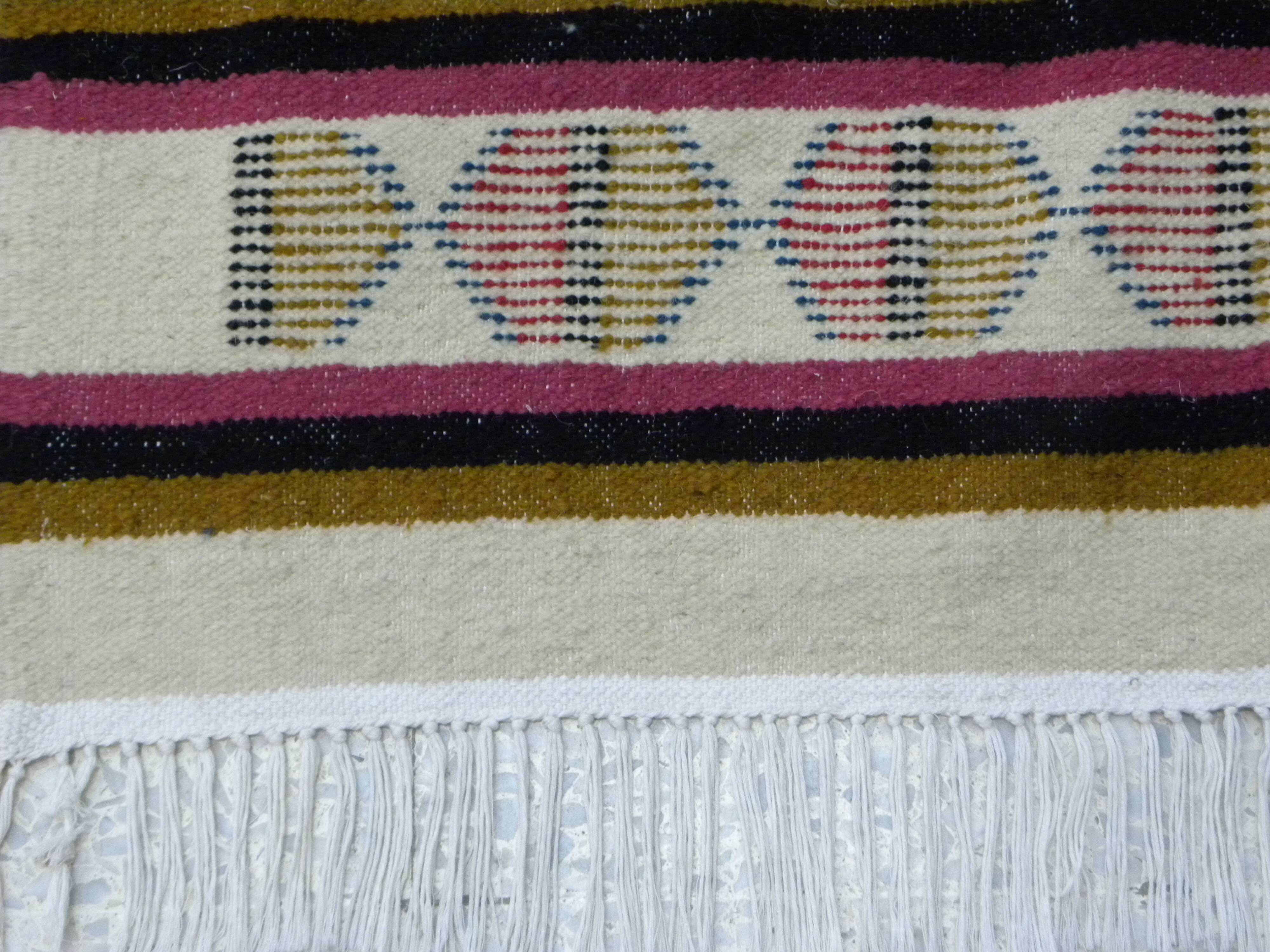 Handmade Berber kilim rug with multicoloured tribal motifs.