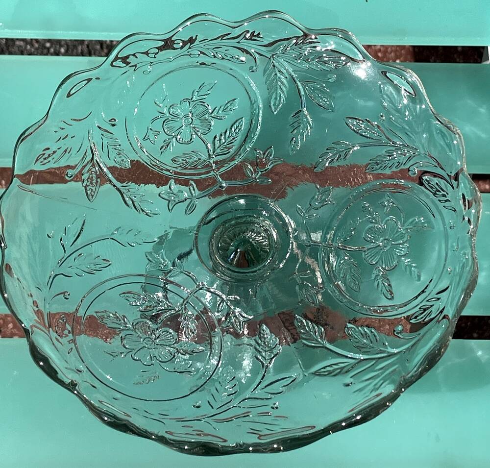Footed bowl or pressed glass compote with floral decoration for table decor.