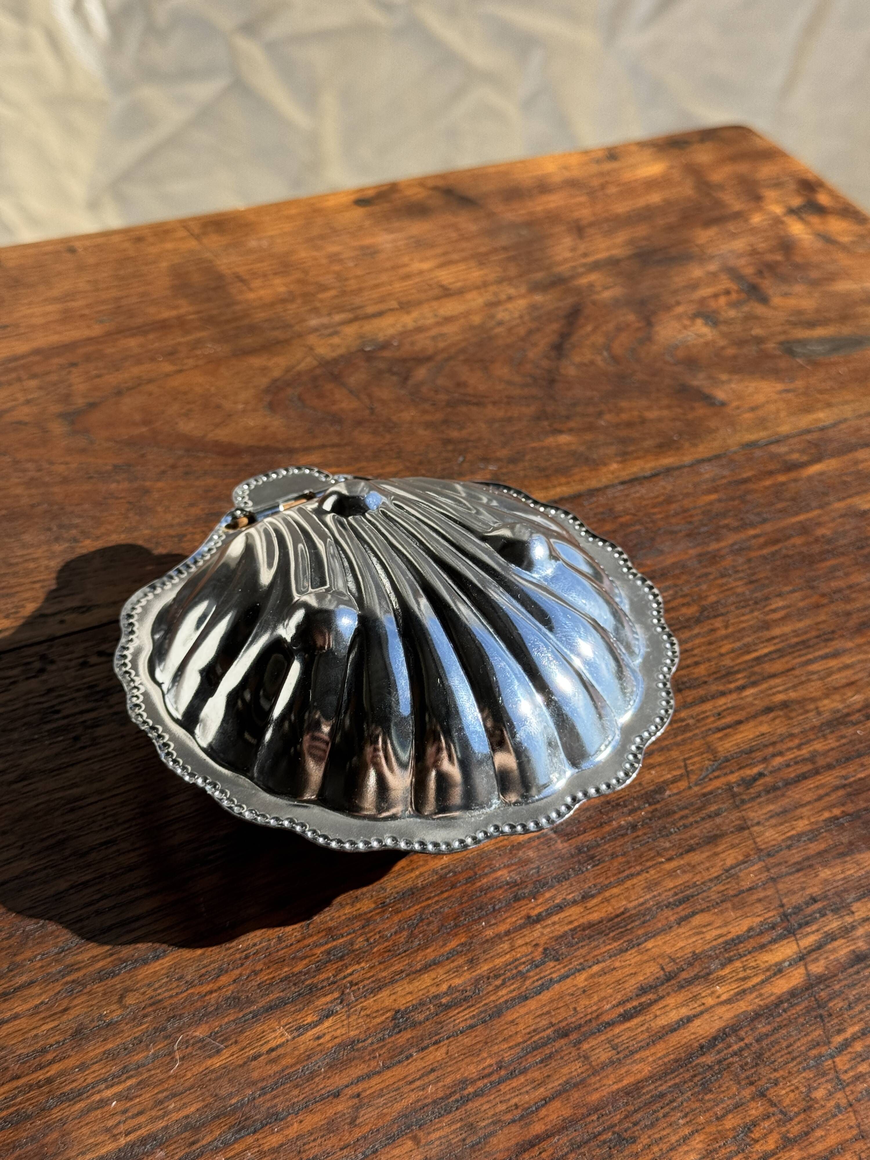 Vintage silver-plated shell butter dish with transparent bowl.