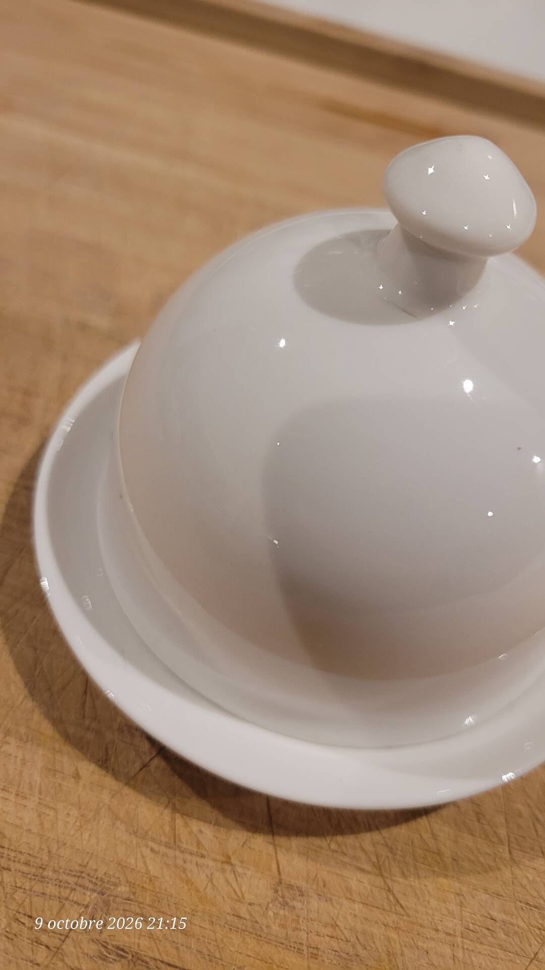 White porcelain butter dish accompanied by its matching bell.