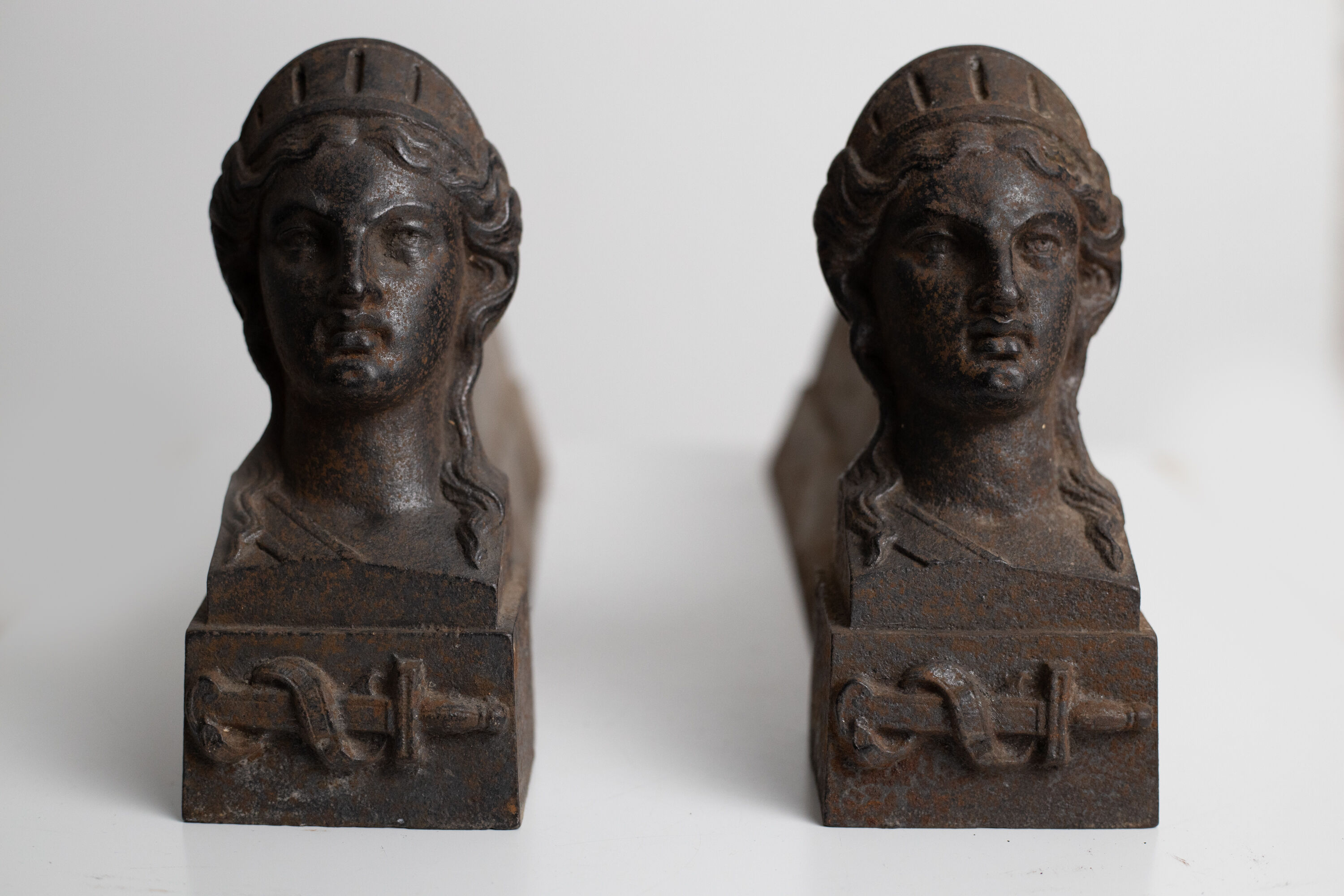 Pair of ancient cast iron chenets adorned with bust of Marianne