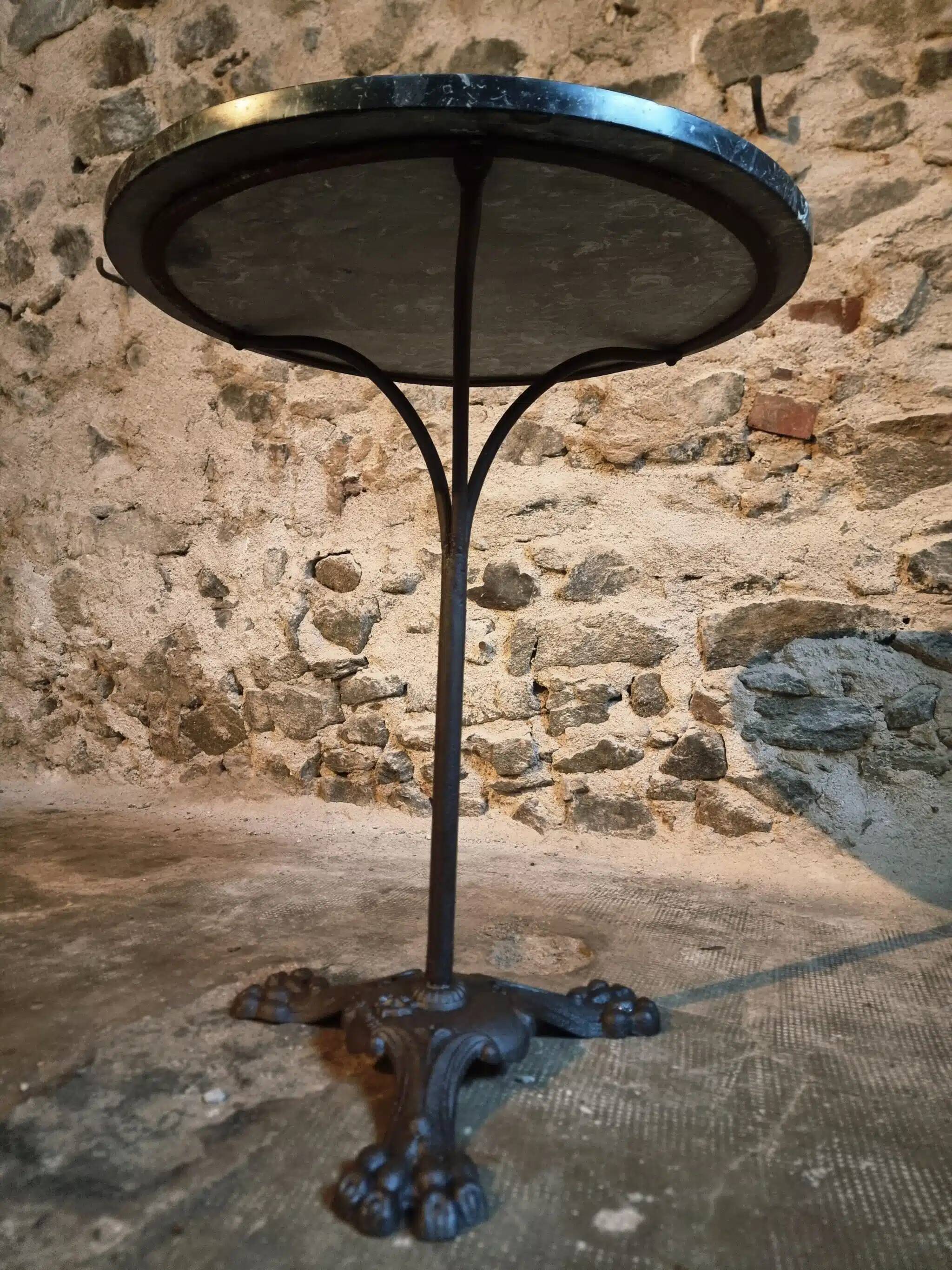 Old French bistro table with a marble top and a cast iron base.