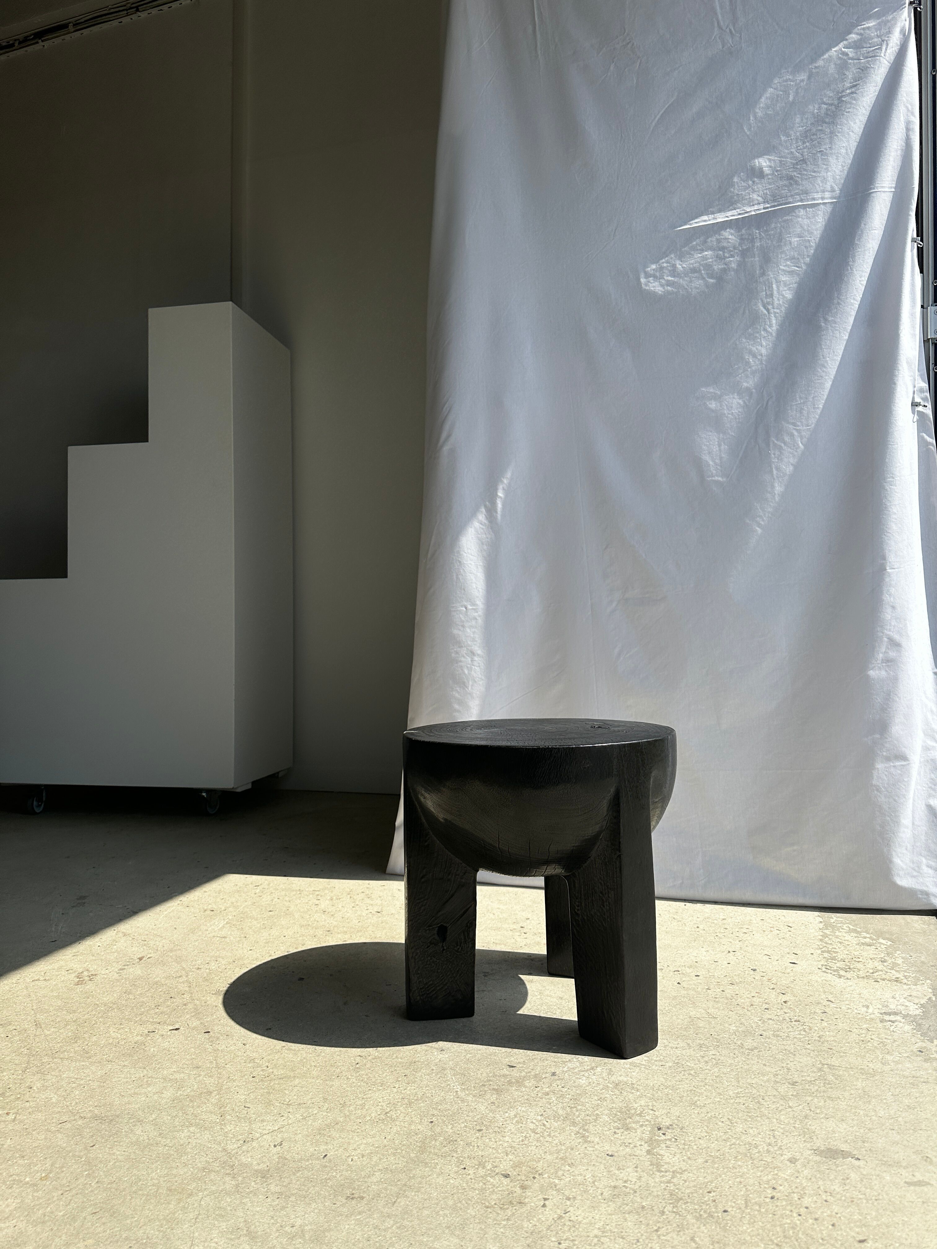 Black mango wood tripod side table with a semi-spherical top, height: 45 cm, diameter: 44 cm.