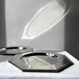 Many octagonal presentation plates in silver-plated metal.
