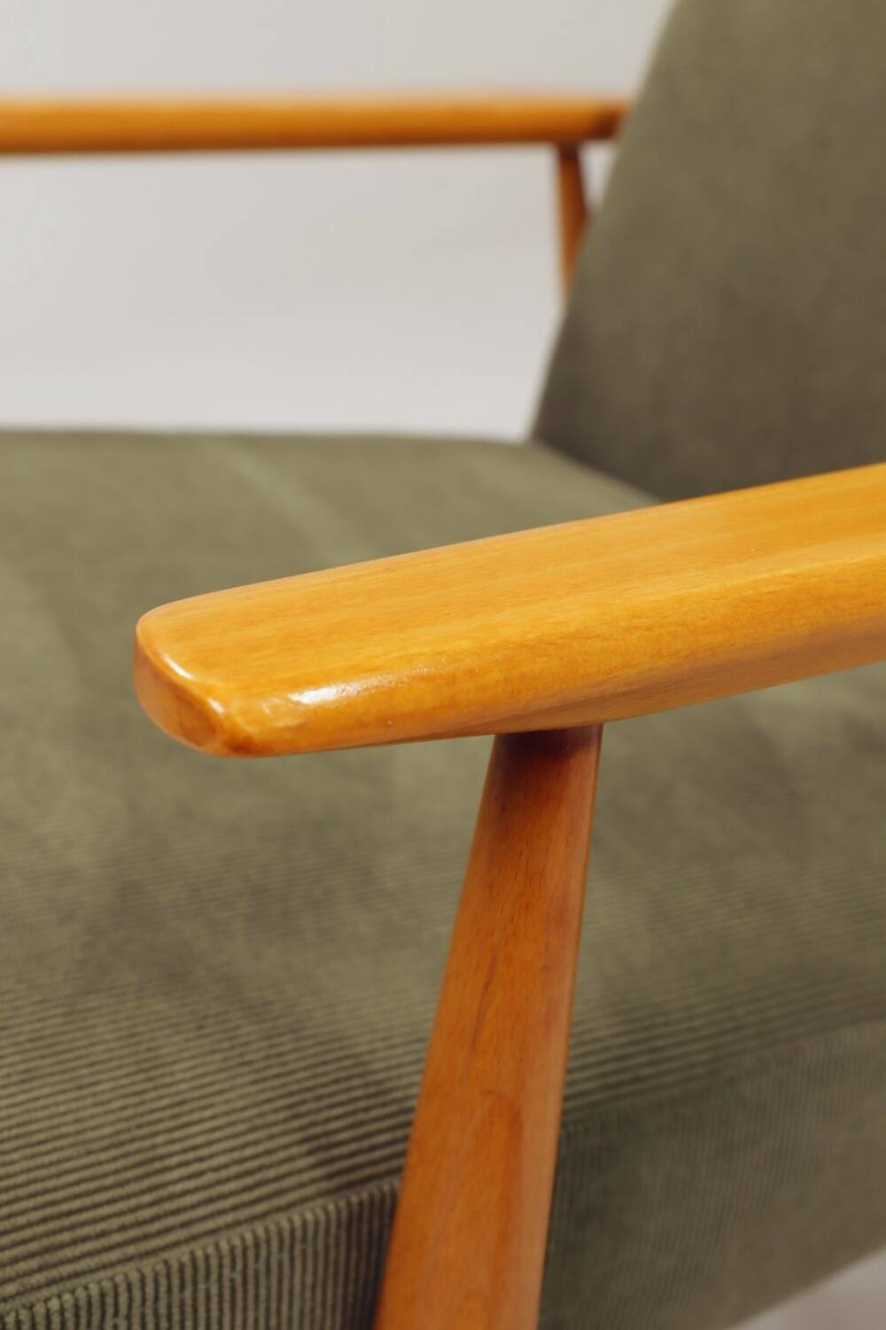 Mid-century modern design armchair in olive green corduroy.