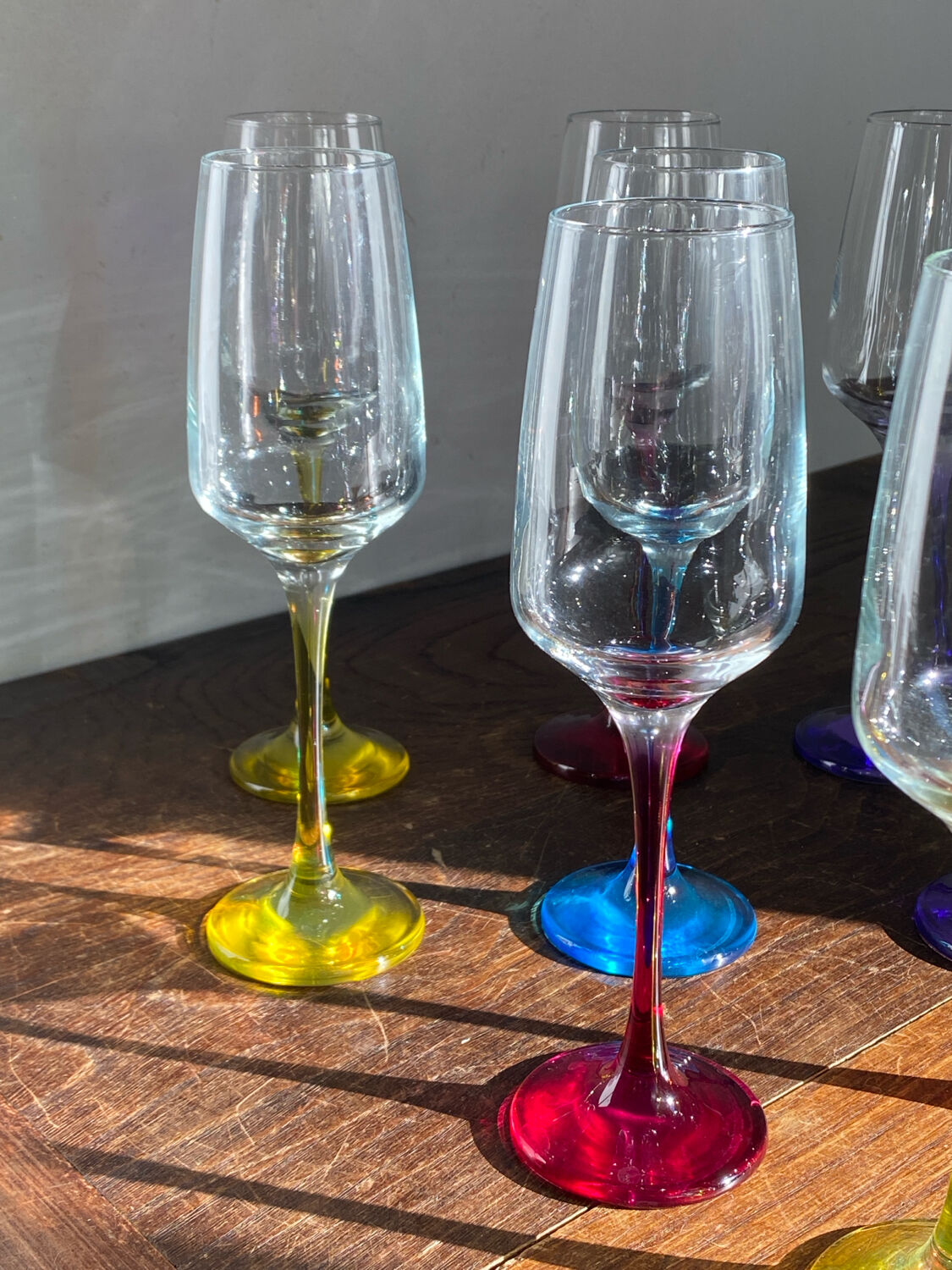 Champagne coupes in glass, multicoloured stems.