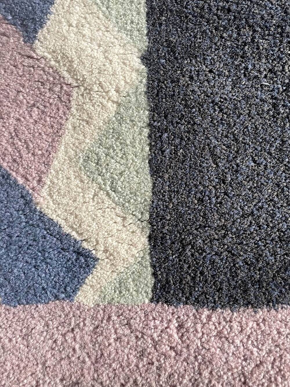 Hand-knotted wool rug by Tisca with a geometric pattern, signed "ILES", France, 1990s.