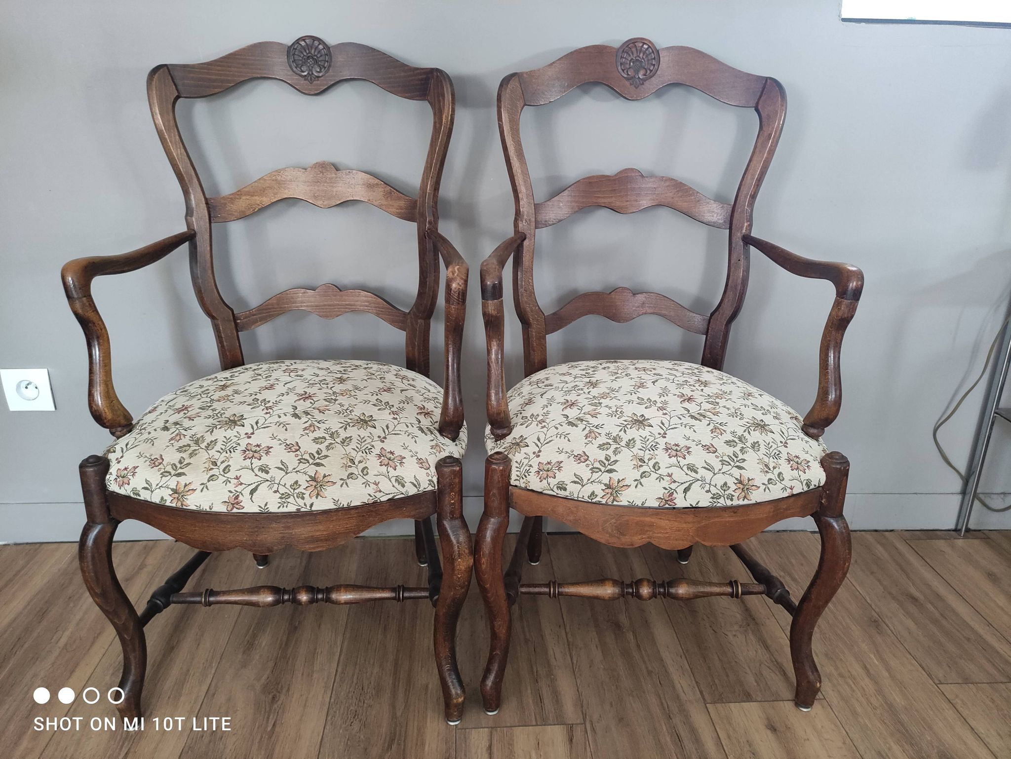 Pair of Provençal armchairs in brown wood and floral fabric.