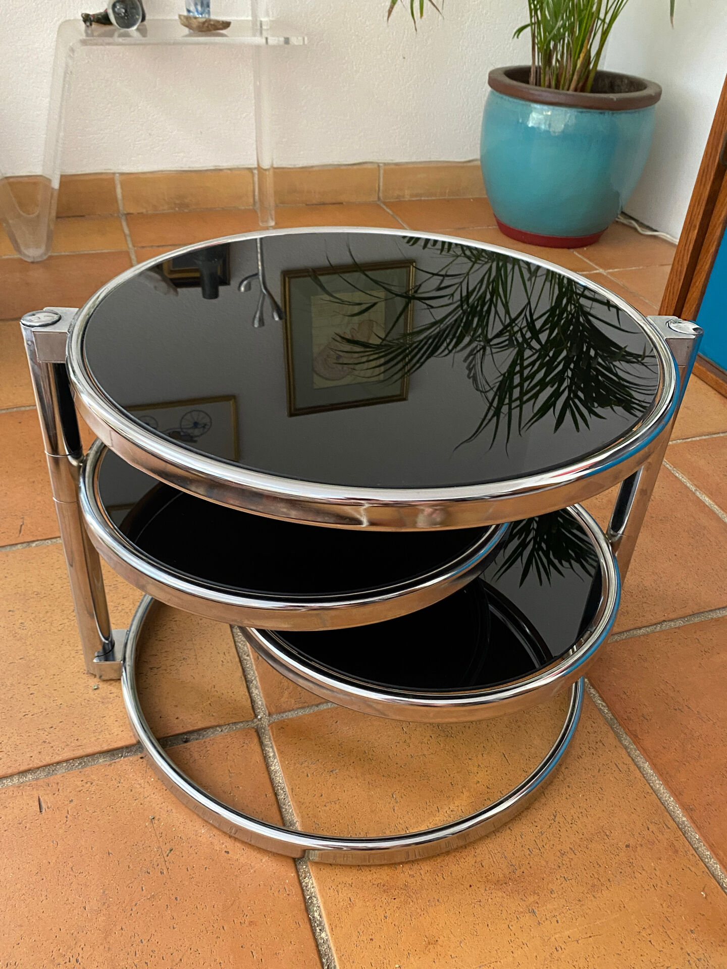 Coffee table with pivoting metal and black glass elements.