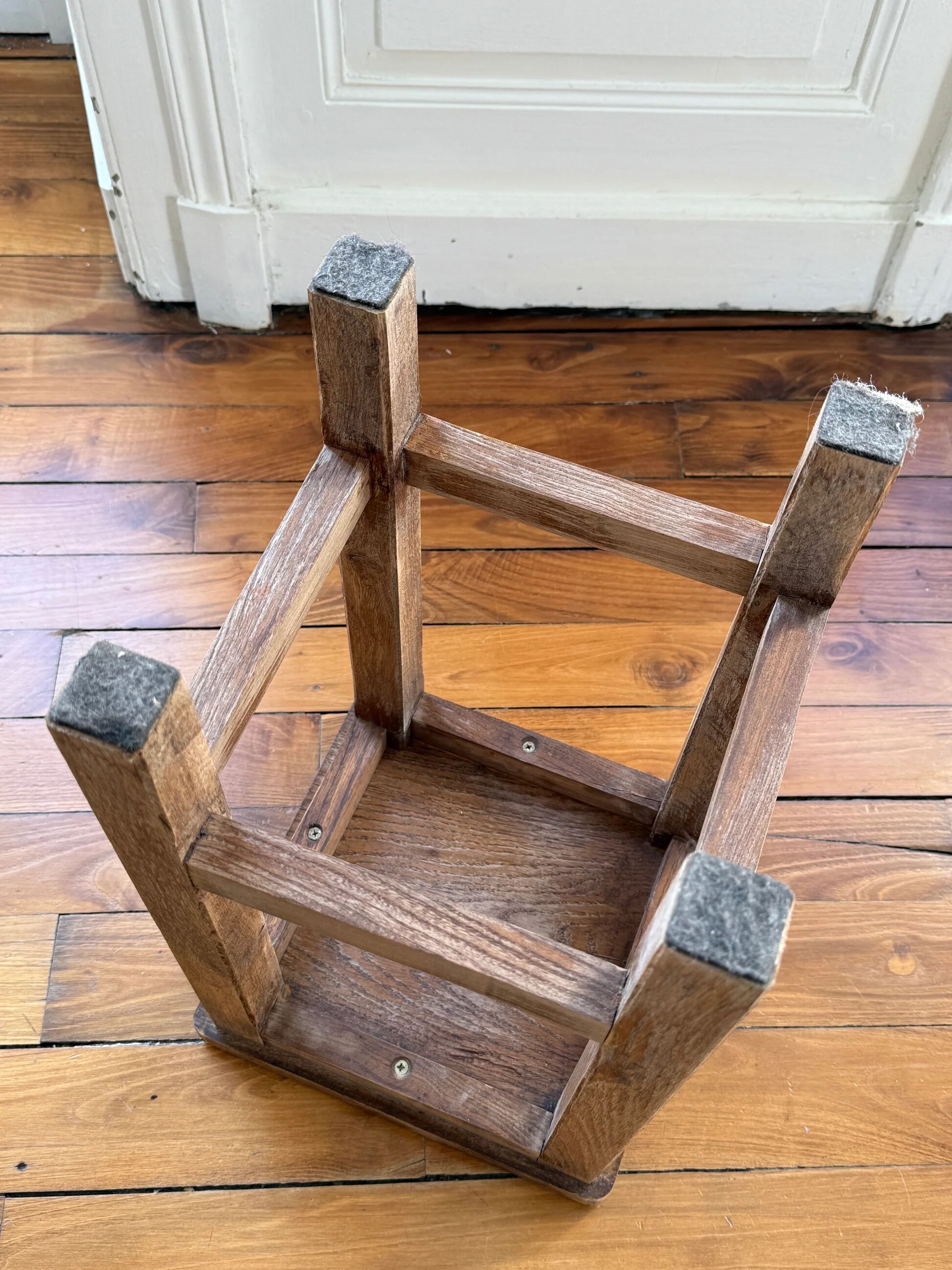 Brutalist stool in raw wood with a weathered effect.