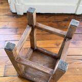 Brutalist stool in raw wood with a weathered effect.